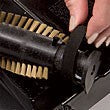 Close-up of Bio SpeedCLEAN replacement brush roll for sweeper being installed with black handle and bristles visible