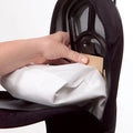 Hand inserting white True-HEPA inner sealed replacement bag into Bio SpeedCLEAN sweeper black compartment