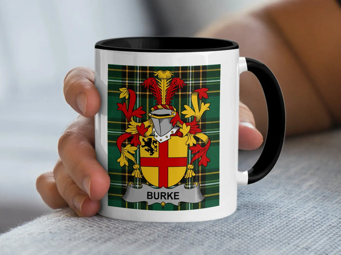 Black-accent Burke mug held in a hand, showing the red-and-gold shield on a tartan background.