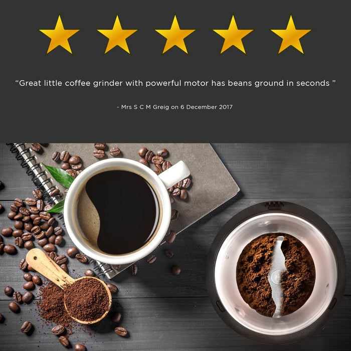 Duronic Electric Coffee Grinder with fresh grounds beside a cup of hot black coffee.