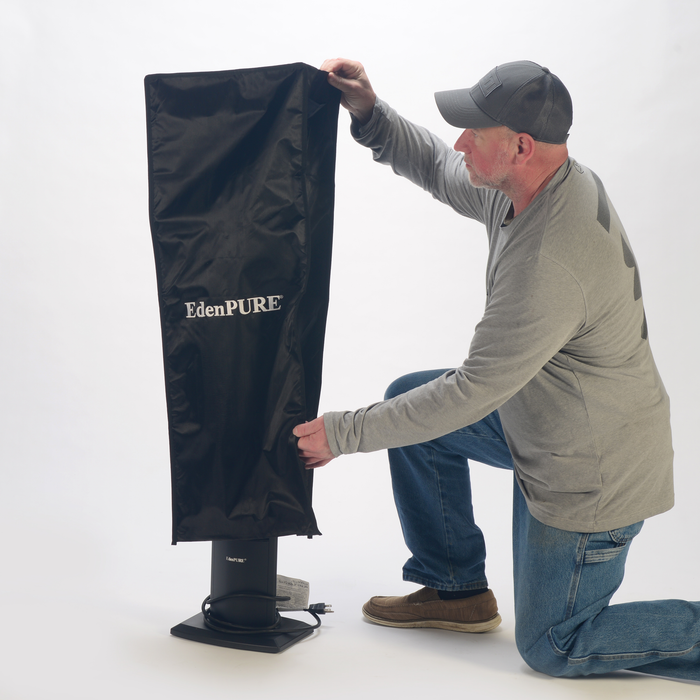 Man in gray shirt and cap placing black EdenPURE All Season Heater Cover over portable indoor/outdoor infrared heater