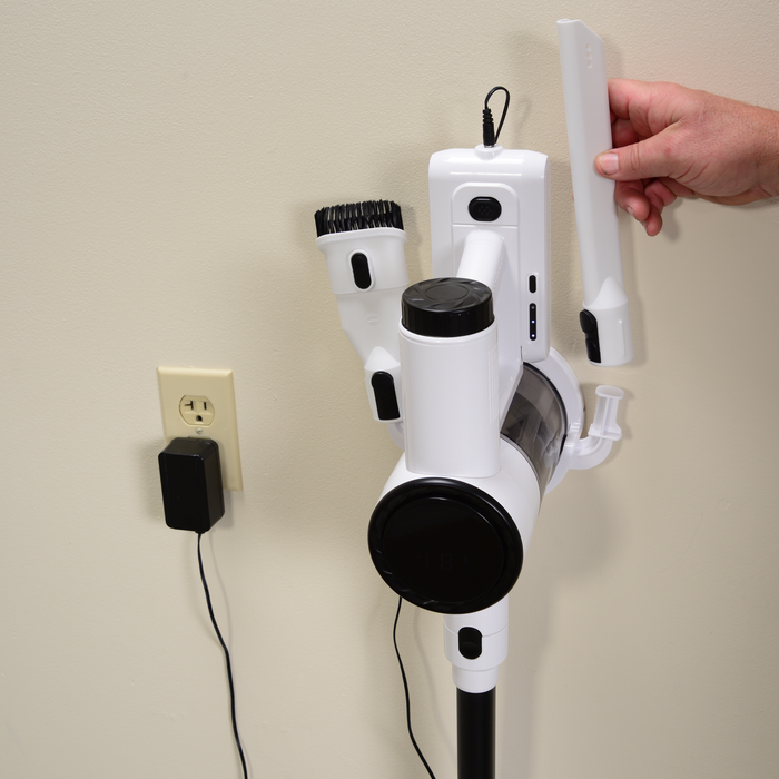 EdenPURE Bio SpeedCLEAN Cordless Vac VX300 charging on wall mount with attachments and hand placing crevice tool