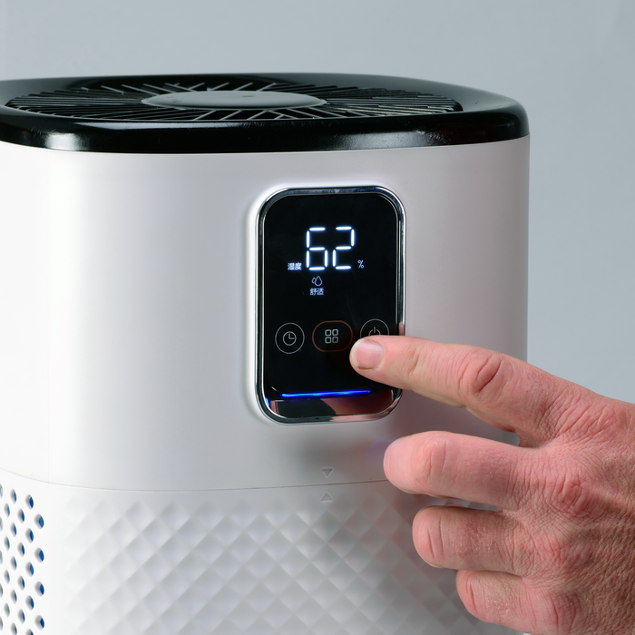 Close-up of EdenPURE Mist-Free Humidifier digital control panel with hand adjusting settings on white body