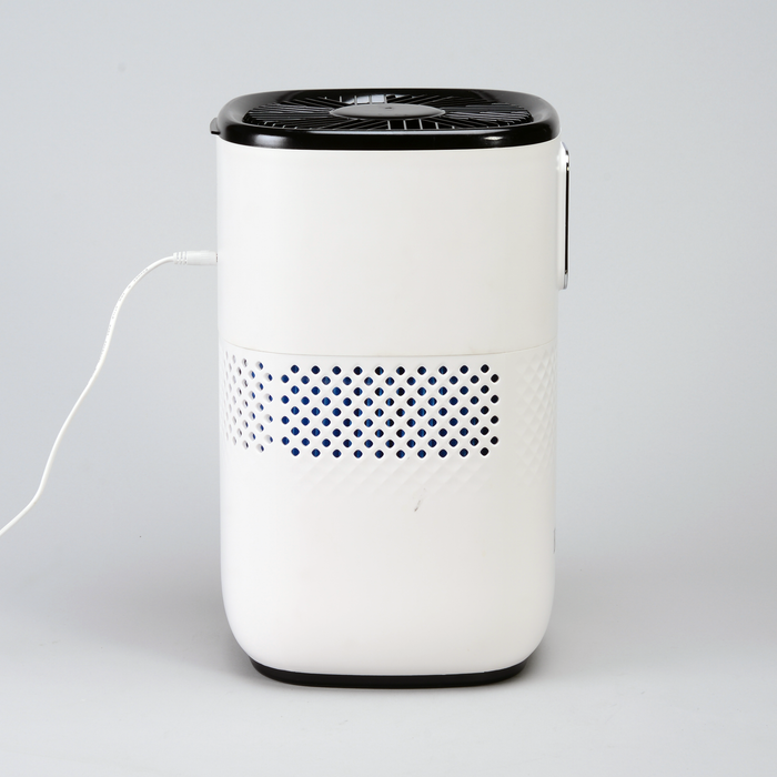 EdenPURE Mist-Free Humidifier with white body, black top vent, and power cord plugged in isolated on gray background