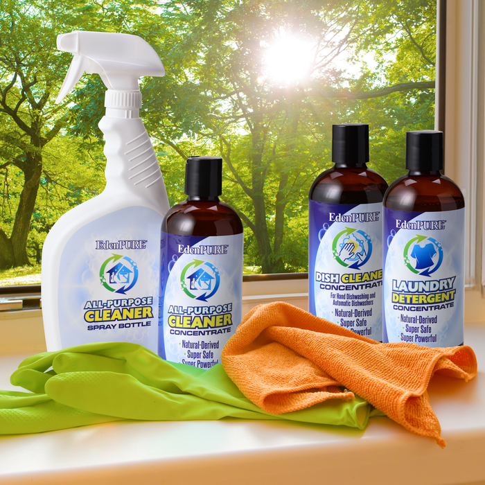 EdenPURE Natural Household Cleaner Kit with spray bottle, concentrate bottles, orange cloth, and green gloves on windowsill