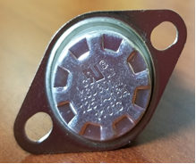 Close-up of Heat Sensor KN004 with metal casing and two mounting holes on wooden surface background