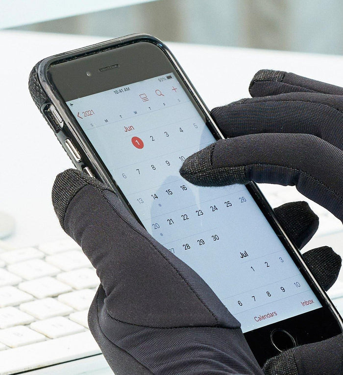Black thin warm typing gloves on hands using a smartphone touchscreen with visible calendar app on screen