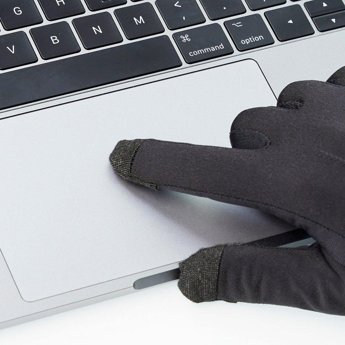 Close-up of The Writer's Glove® thin, warm black glove with touchscreen fingertips typing on laptop trackpad