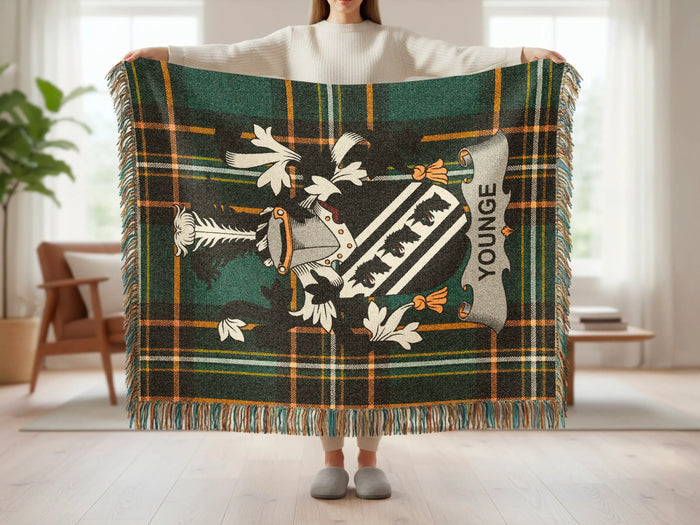 Tartan blanket with a family crest and "YOUNGE" text displayed by a person.